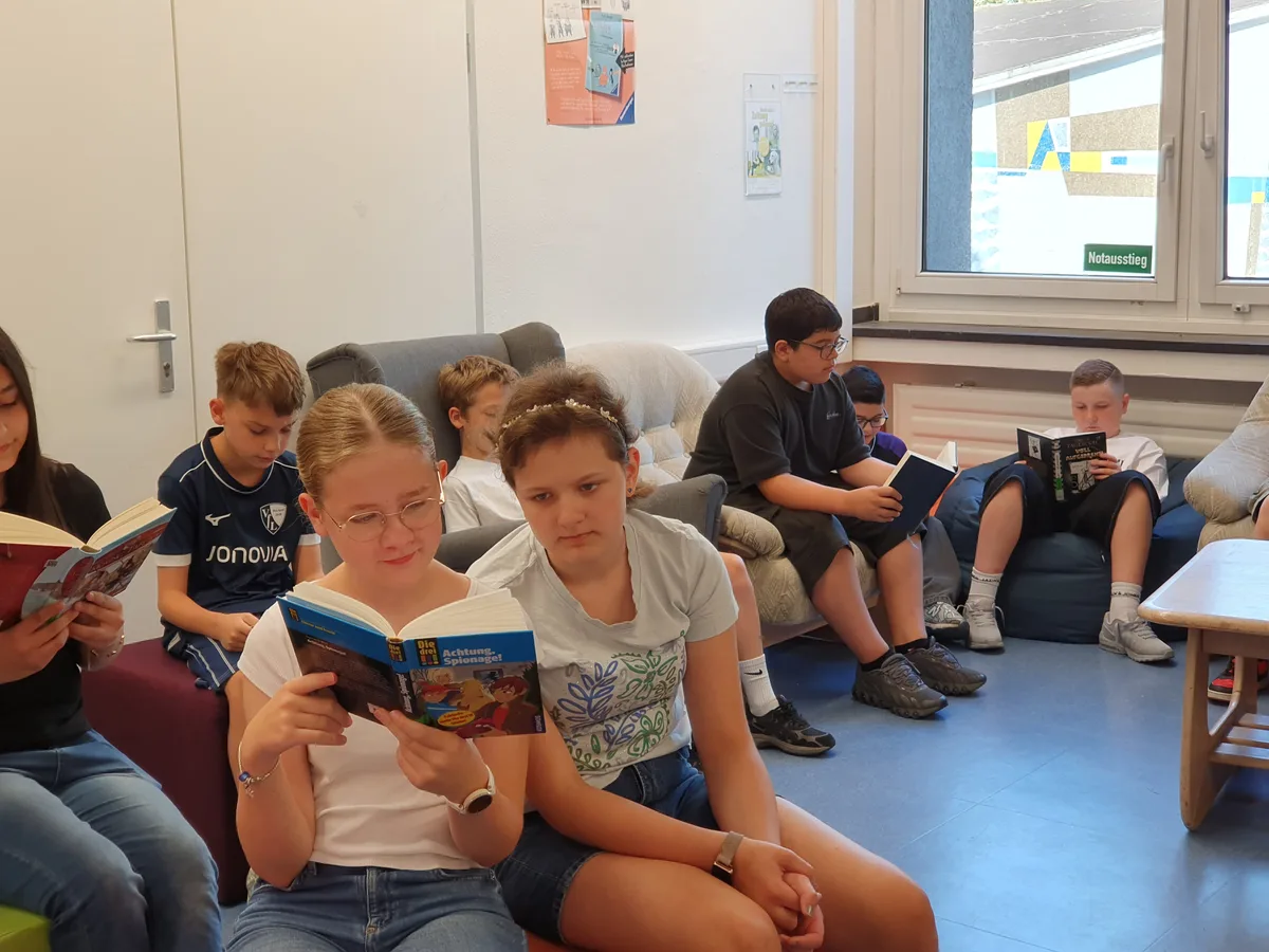 Zwei Schülerinnen lesen gemeinsam in einem Buch